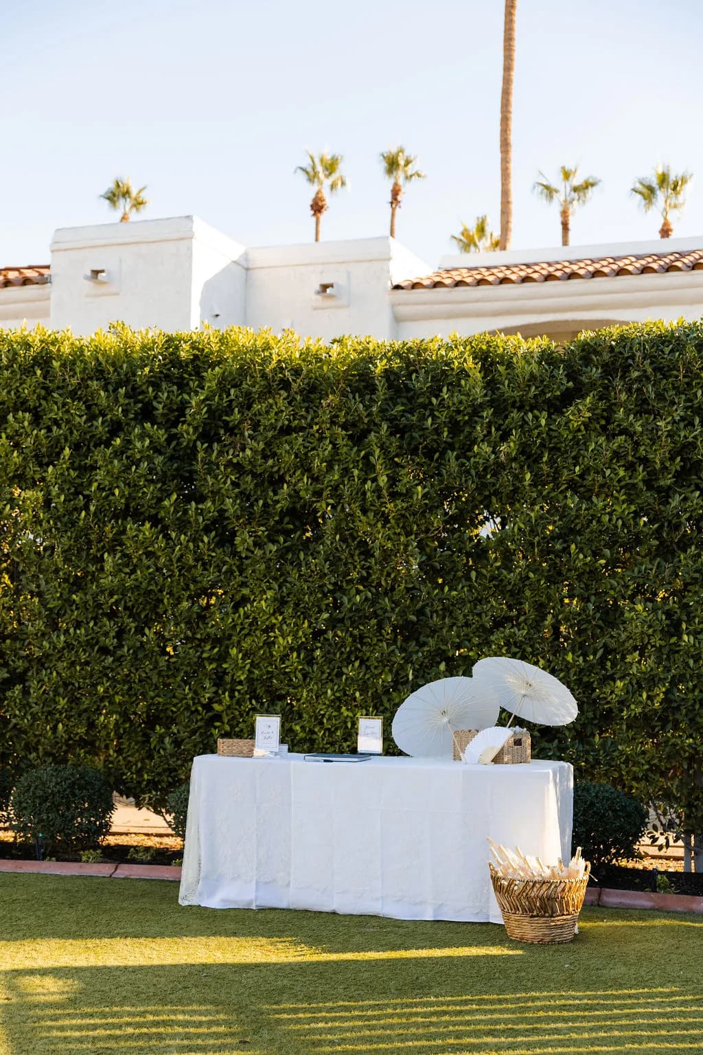Parasol welcome table against manicured hedges at Kimpton Miralina