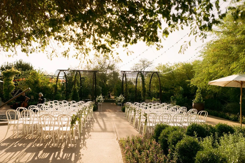 Desert Botanical Garden wedding ceremony setup at golden hour with garden arbors and string lights