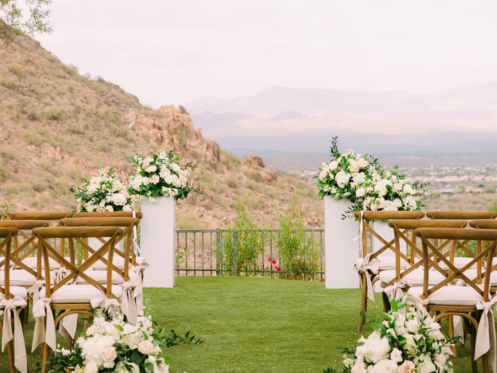 Ceremony aisle with white floral pillars overlooking the valley at Adero Scottsdale Resort