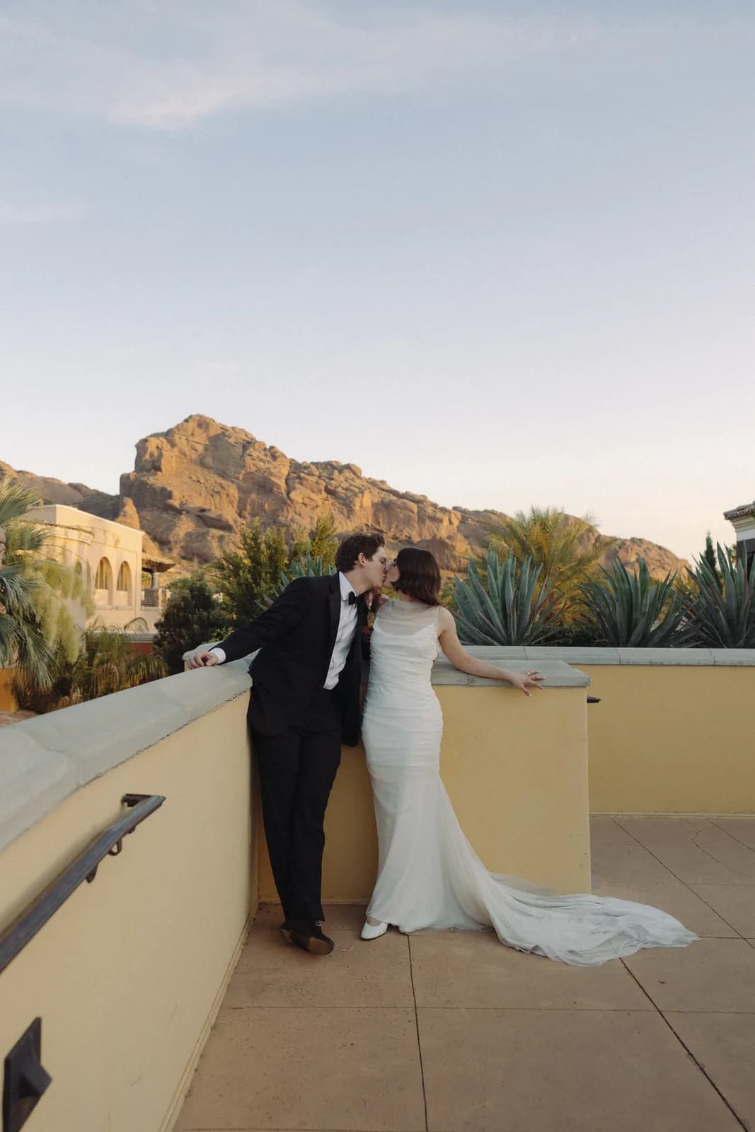 Newlyweds on a terrace with Camelback Mountain behind them at Omni Montelucia