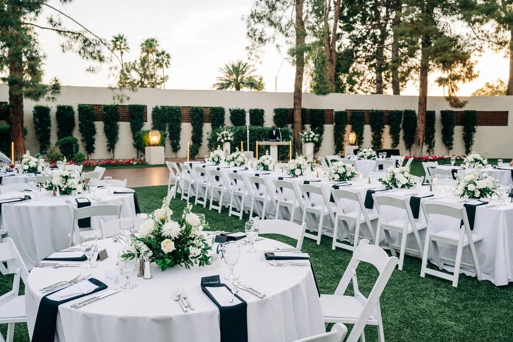 Sunset lawn reception with white tables beneath the palms at The Scottsdale Resort & Spa